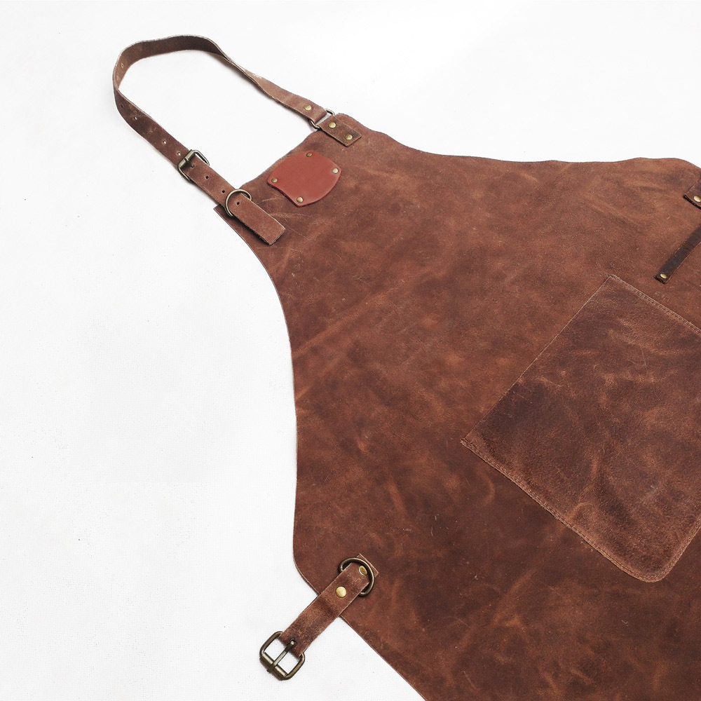 Detail des braunen Leders, der Vordertasche und der Schnallen der Lederschürze
