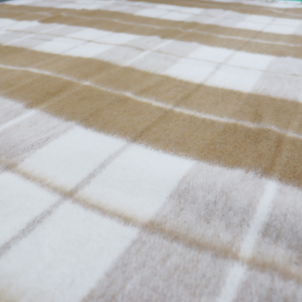 Detail des beige-cremefarbenen Karomusters und Wollgewebes der Decke Camel