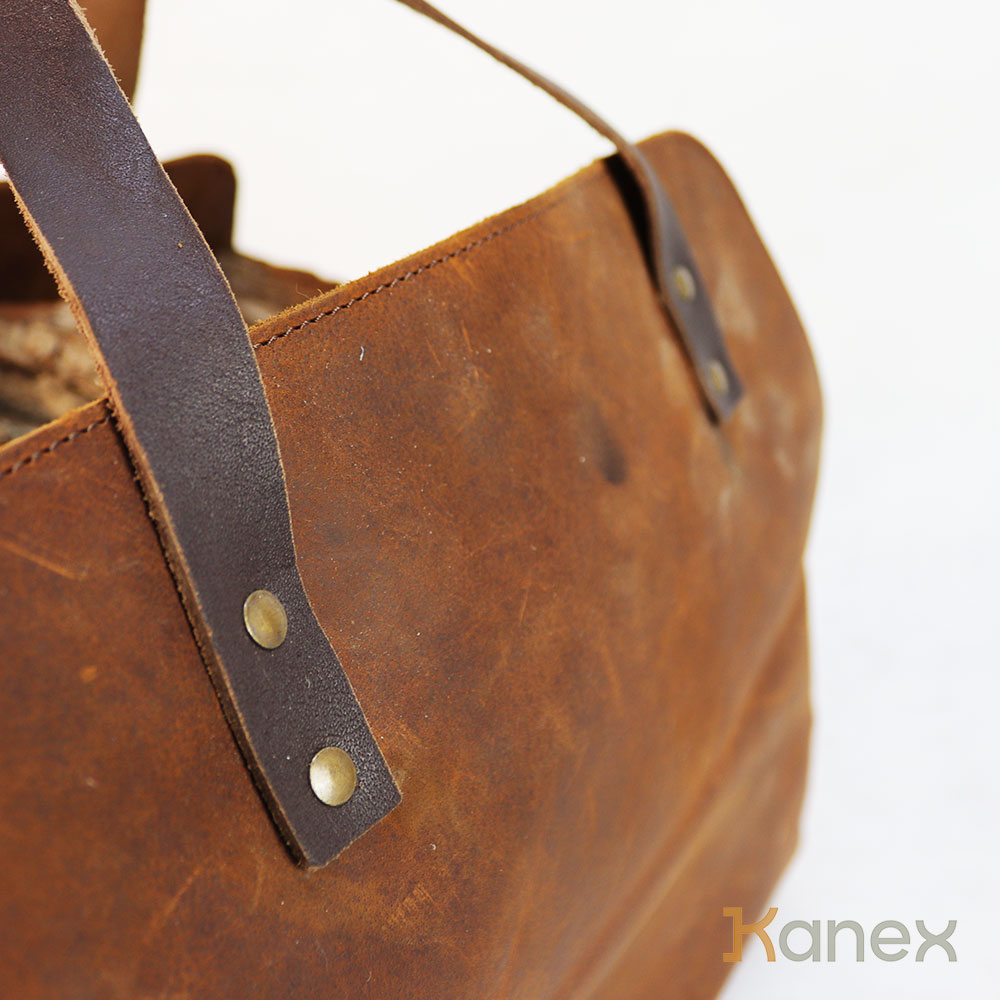 Detail der Lederoberfläche und genieteten Tragegriffe der Kaminholztasche Detail der Lederoberfläche und genieteten Tragegriffe der Kaminholztasche